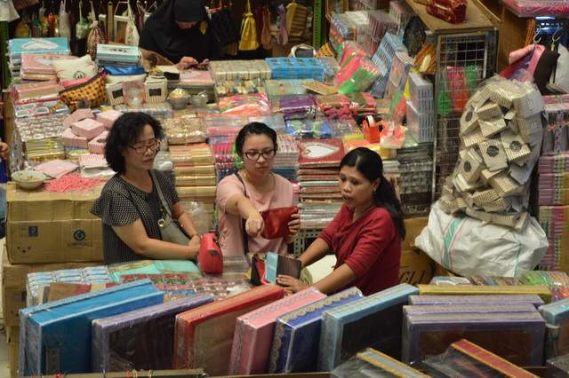 Salah satu penjual souvenir yang sedang melayani pelanggan di Pasar Jatinegara